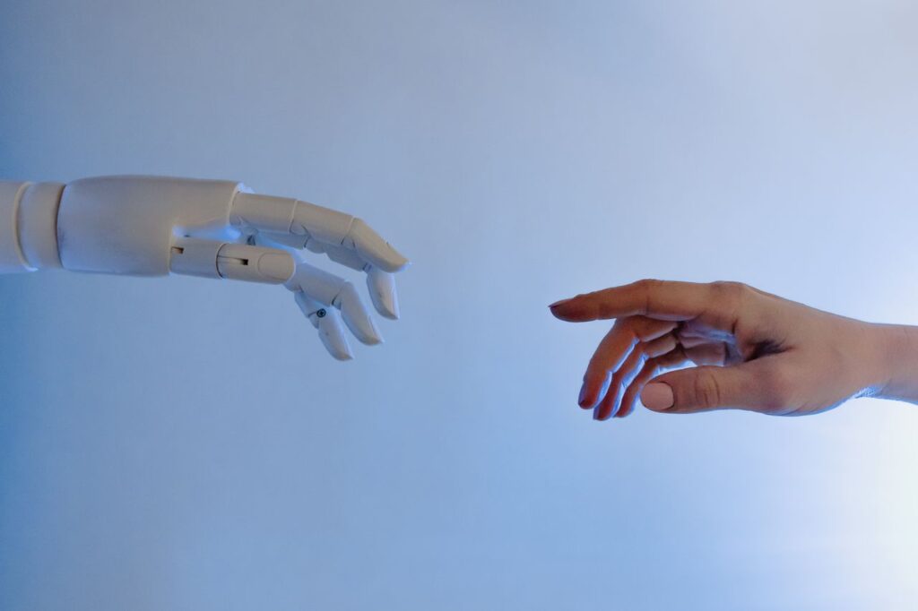Mano humana y robótica acercándose para el AI Act
